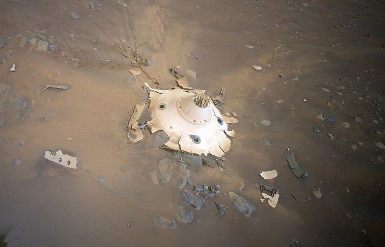In an image provided by NASA/JPL-Caltech shows the Mars helicopter Ingenuity showing the backshell of Perseverance’s landing capsule, its supersonic parachute and the related debris field on April 19, 2022. The debris was part of the equipment that helped the Perseverance mission safely land on the red planet in 2021. (NASA/JPL-Caltech via The New York Times) — EDITORIAL USE ONLY — XNYT203 XNYT203