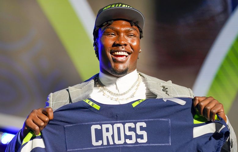 Mississippi State offensive lineman Charles Cross holds a jersey after being chosen by the Seattle Seahawks with the ninth pick of the NFL football draft Thursday, April 28, 2022, in Las Vegas. (AP Photo/John Locher ) CAMS242