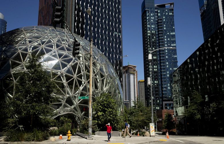 Between January and March, Amazon saw net sales increase to $116 billion but reported a net loss of $3.8 billion. Pedestrians pass by the Amazon’s Spheres in Seattle in 2020. (Erika Schultz / The Seattle Times, file)
