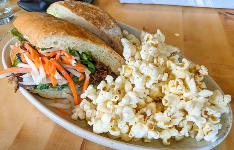 The sandwiches at Vinbero come standard with a side of fresh popcorn, tossed in butter, salt, and pepper. The banh mi comes stuffed with a pile of pickled carrots and daikon radish.