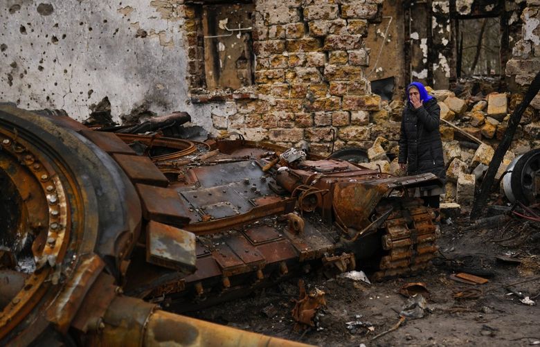 Valentyna Sherba, 68, stands next to a Russian tank in the backyard of her father’s home, both destroyed, in the aftermath of a battle between Russian and Ukrainian troops on the outskirts of Chernihiv in northern Ukraine, Saturday, April 23, 2022. (AP Photo/Francisco Seco) XLM323 XLM323