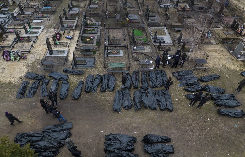Policemen work on the identification process following the killing of civilians in Bucha, before sending the bodies to the morgue, on the outskirts of Kyiv, Ukraine, Wednesday, April 6, 2022. (AP Photo/Rodrigo Abd) ABD107 ABD107