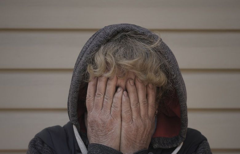 Natalya, whose husband and nephew were killed by Russian forces, cries in her garden in Bucha, Ukraine, Monday, April 4, 2022. Russia faced a fresh wave of condemnation on Monday after evidence emerged of what appeared to be deliberate killings of civilians in Ukraine. (AP Photo/Vadim Ghirda) XVG107 XVG107