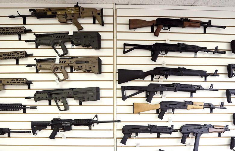 In this photo taken Tuesday, Oct. 2, 2018, semi-automatic rifles fill a wall at a gun shop in Lynnwood, Wash. Voters in Washington state will decide the fate of Initiative 1639, which seeks to curb gun violence by toughening background checks for people buying semi-automatic rifles, increasing the age limit to 21 for buyers of those guns and requiring safe storage of all firearms. (AP Photo/Elaine Thompson) OTK OTK
