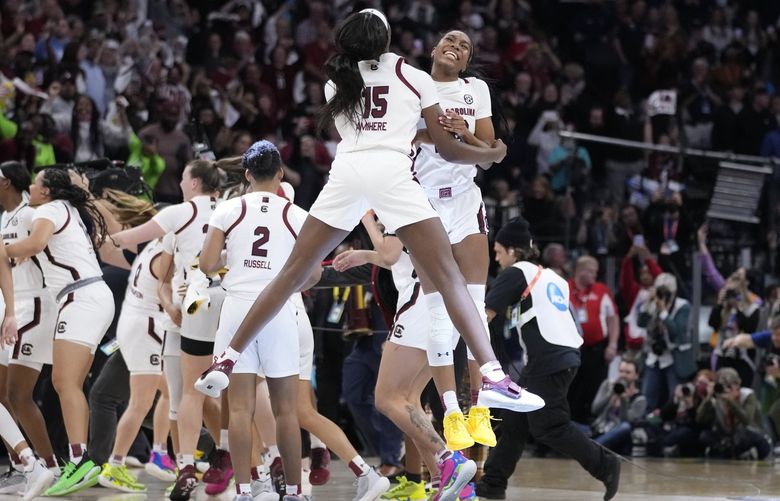 South Carolina’s Laeticia Amihere and Bree Hall celebrate after a college basketball game in the final round of the Women’s Final Four NCAA tournament against UConn Sunday, April 3, 2022, in Minneapolis. South Carolina won 64-49 to win the championship. (AP Photo/Charlie Neibergall) MNMG180 MNMG180