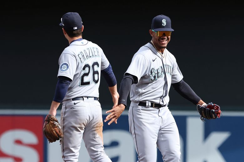 Mariners second baseman Adam Frazier (26) high fives teammate center fielder Julio Rodriguez in celebration after winning 4-3 against the Minnesota Twins on Saturday in Minneapolis. (AP Photo/Stacy Bengs)