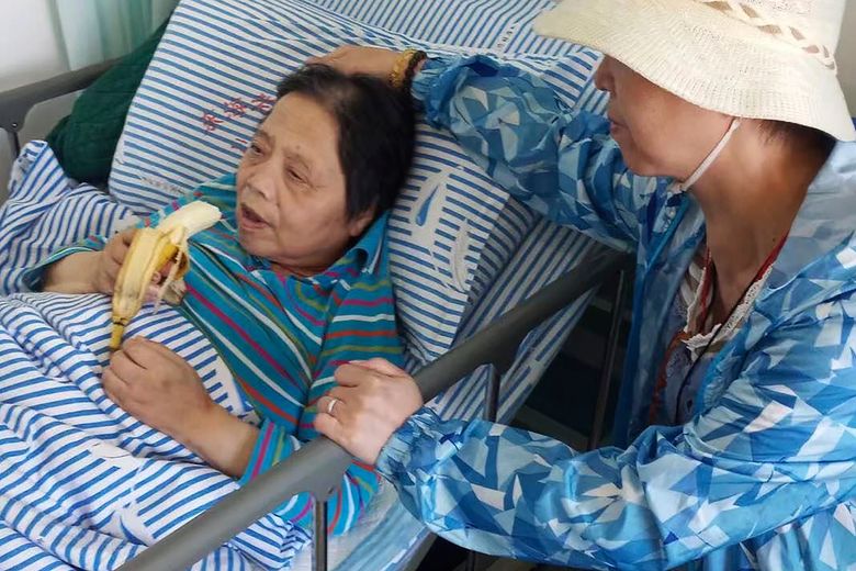 在沉培铭家人发布的这张照片中，71 岁的沉培铭于 2019 年 9 月 24 日在上海东海养老医院的床边照顾她的家人吃香蕉。沉培铭于 4 月周日上午去世2022 年 3 月 3 日，在医院，身边没有亲人。 由于大流行的限制，她的家人无法探望，不确定她的死因。 该医院报告了 COVID-19 疫情，但截至上周，沉的检测结果为阴性。 （沉培明的家人通过美联社）