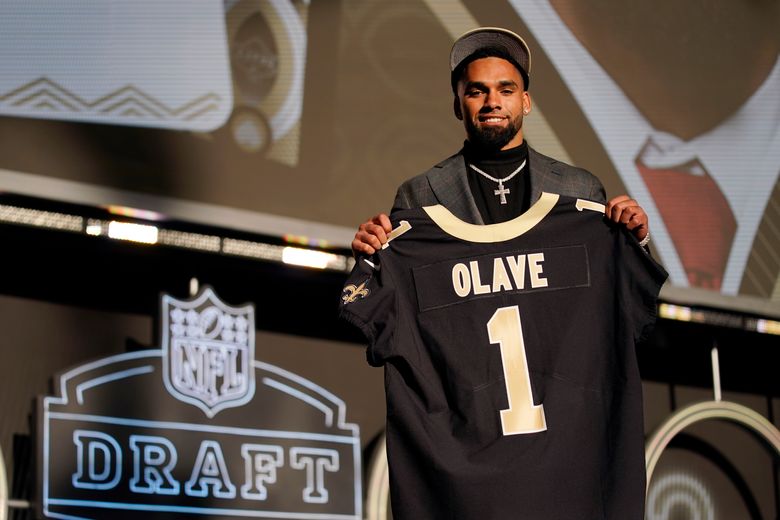 New Orleans Saints first round draft pick, wide receiver Chris Olave (12),  high fives quarterback Jameis