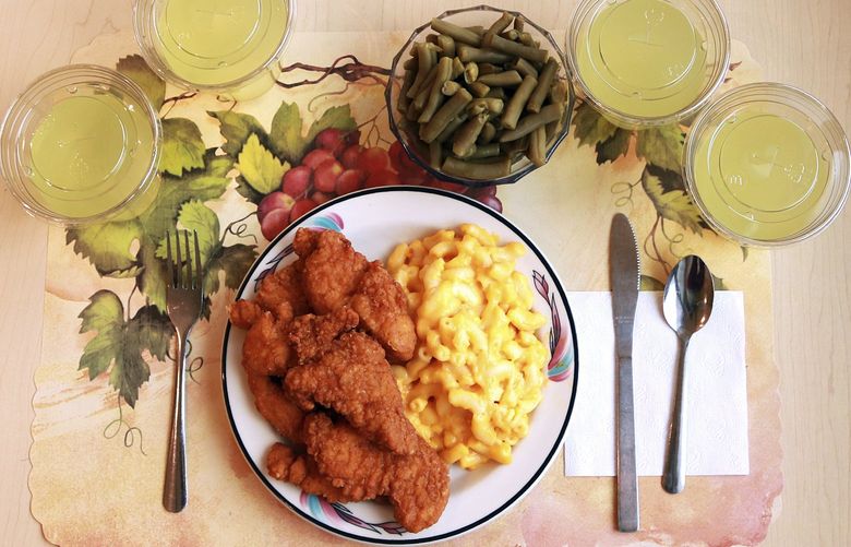 This undated photo provided by the National Institutes of Health in June 2019 shows an “ultra-processed” lunch including brand name macaroni and cheese, chicken tenders, canned green beans and diet lemonade. Researchers found people ate an average of 500 extra calories a day when fed mostly processed foods, compared with when the same people were fed minimally processed foods. Thatâ€™s even though researchers tried to match the meals for nutrients like fat, fiber and sugar. (Paule Joseph, Shavonne Pocock/NIH via AP)