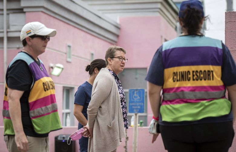 Dr. Cheryl Hamlin, center, who travels to Mississippi from Massachusetts to help women who are seeking abortions, speaks with clinic escorts outside the Jackson Women’s Health Organization in Jackson, Miss., May 3, 2022. A draft opinion leaked from the Supreme Court has indicated that a majority of the justices were in favor of overturning the constitutional right to abortion, a decision that could spell the end of clinics like this one, the lone provider in Mississippi and the named plaintiff in the case that will lead to the most consequential abortion rights decision in decades. (Rory Doyle/The New York Times) XNYT326 XNYT326