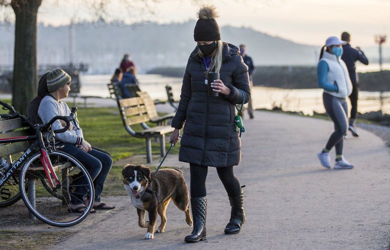 A woman walks her dog at Golden Gardens on Tuesday. There are a few trails around the park and a path adjacent to the beach that provides for a short, scenic walk

Tuesday, Jan. 19, 2020 216124