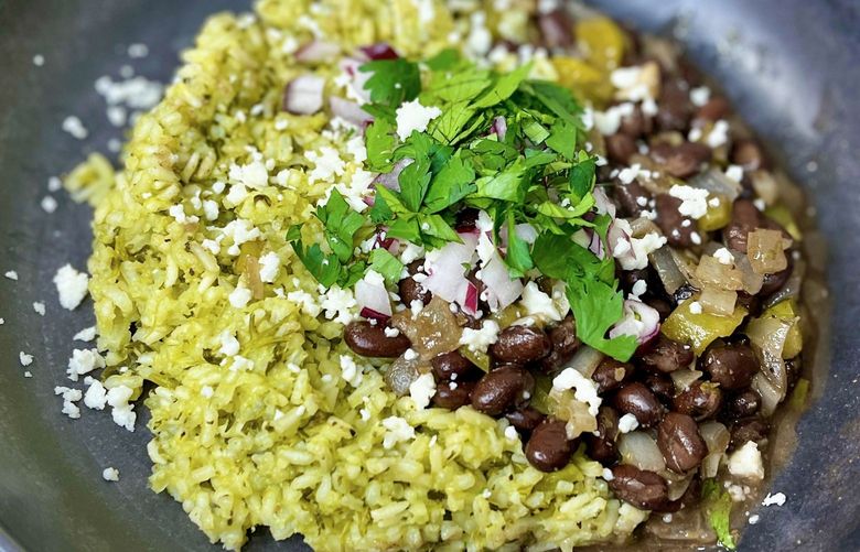 Green rice, made with a savory green sauce consisting of spinach, roasted jalapenos, and tomatillos blended together with additional herbs and spices, and served with some delicious Cuban-style black beans, make a hearty meal or a delicious side.