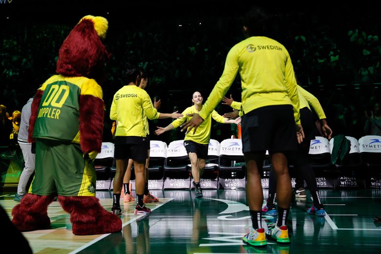 Seattle Storm guard Sue Bird gets high-fives from teammates as she is introduced to the crowd before the start of the season opener against the Minnesota Lynx at Climate pledge Arena, Friday, May 6, 2022, in Seattle. (Jennifer Buchanan / The Seattle Times)