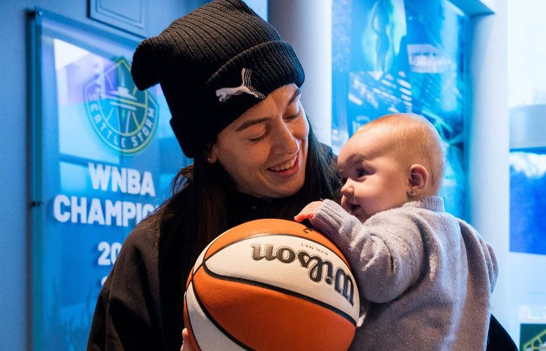 Breanna Stewart CQ holds her daughter Ruby Mae Stewart Xargay, 6 months, before a press conference in Seattle Thursday, Feb. 10, 2022. Stewart’s wife Marta Xargay Casademont is behind. 219540