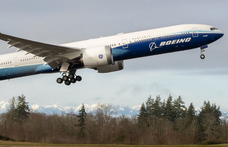 As the Olympic Mountains loom in the distance, the Boeing 777X takes off on its inaugural flight from Paine Field in Everett, Wash., at 10:10 a.m. January 25, 2020. The 777X features giant carbon-composite wings, the largest Boeing has ever designed. The wings are so long that to fit at standard airport gates, each has to fold upward on a hinge 11 feet from the tip. 212736