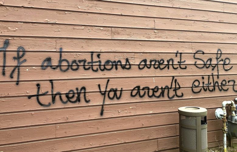 Threatening graffiti is seen on the exterior of Wisconsin Family Action offices in Madison, Wis., on Sunday, May 8, 2022. The Madison headquarters of the anti-abortion group was vandalized late Saturday or early Sunday, according to an official with the group. (Alex Shur/Wisconsin State Journal via AP) WIMAW101 WIMAW101