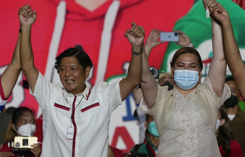 FILE – Presidential candidate, Ferdinand Marcos Jr., the son of the late dictator, left, raises arms with running mate Davao City Mayor Sara Duterte, the daughter of the current President, during their last campaign rally Saturday, May 7, 2022, in Paranaque city, Philippines. Marcos Jr. and Duterte are the new leaders of the Philippines, an alliance that ushers in six years of governance that has some human rights activists concerned about the course their country may take with the pair in power. (AP Photo/Aaron Favila, File) BKWS337 BKWS337