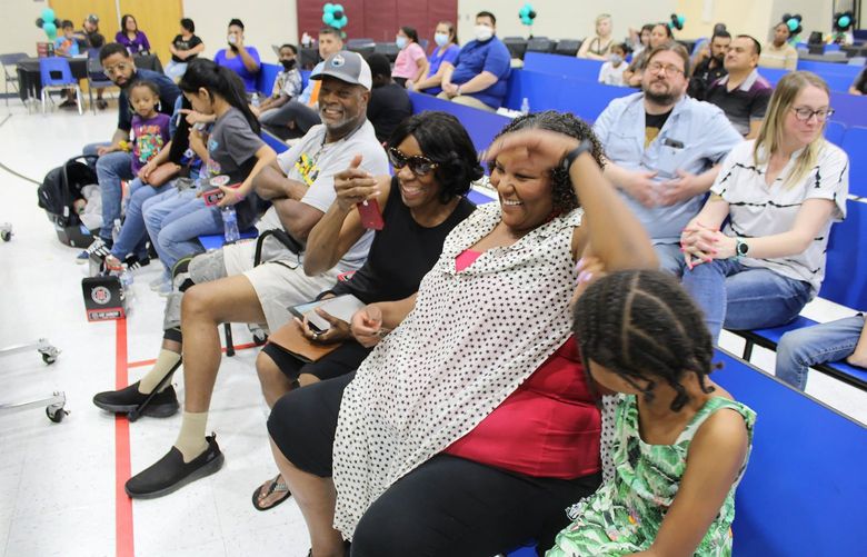 Parents of third-graders at Bernard Black Elementary School react as they learn their children will get full college scholarships. MUST CREDIT: Roosevelt School District.