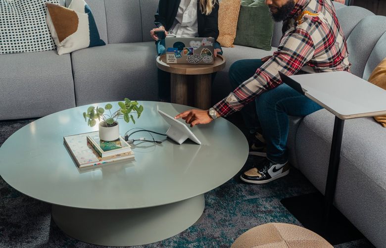 An employee sets up a meeting in a lounge-style conference room, which lacks a central table entirely, at the offices of LinkedIn, in Mountain View, Calif., April 15, 2022. As workers return to the office, some companies have tried new tweaks to make spaces more welcoming and collaborative – even the little-loved conference room. (Kelsey McClellan/The New York Times) XNYT122 XNYT122
