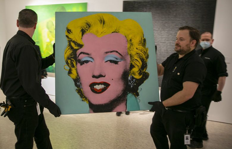FILE – The 1964 silk-screen image, “Shot Sage Blue Marilyn,” by Andy Warhol is carried in Christie’s showroom in New York, Sunday, May 8, 2022. The image sold for $195 million, Monday, May 9. (AP Photo/Ted Shaffrey, File) NYSB169 NYSB169