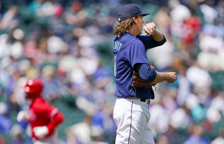 Seattle Mariners starting pitcher Logan Gilbert, center, as Philadelphia Phillies’ Rhys Hoskins, left, rounds the bases after hitting a grand slam during the fourth inning of a baseball game, Wednesday, May 11, 2022, in Seattle. (AP Photo/Ted S. Warren) 220348