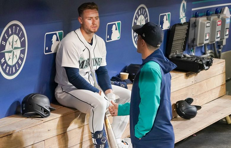 Seattle Mariners’ Jarred Kelenic, left, talks with a teammate in the dugout after a baseball game against the Philadelphia Phillies, Monday, May 9, 2022, in Seattle. The Phillies won 9-0. (AP Photo/Ted S. Warren) WATW120