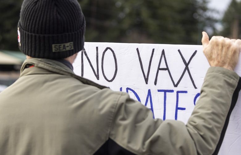 A protester waves to cars outside Department of Health offices in Tumwater to challenge the state Board of Health with false claims that the board is passing rules to involuntarily quarantine COVID-19 vaccine refusers, on Wednesday, Jan. 12, 2022.

About 200 protesters showed up to express anger at the nonexistent and false quarantine plot, as well as a real — but very early stage — study of whether to mandate COVID-19 vaccines for children to attend K-12 schools.
