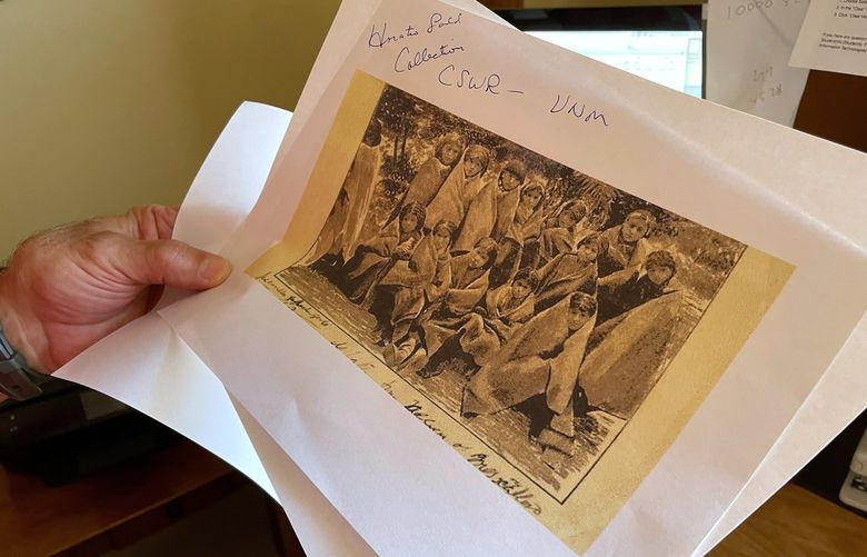 FILE – In this July 8, 2021, photo, adjunct history professor and research associate Larry Larrichio holds a copy of a late 19th century photograph of pupils at an Indigenous boarding school in Santa Fe during an interview in Albuquerque, New Mexico. The U.S. Interior Department is expected to release a report Wednesday, May 11, 2022, that it says will begin to uncover the truth about the federal government’s past oversight of Native American boarding schools. (AP Photo/Susan Montoya Bryan, File) LA202 LA202