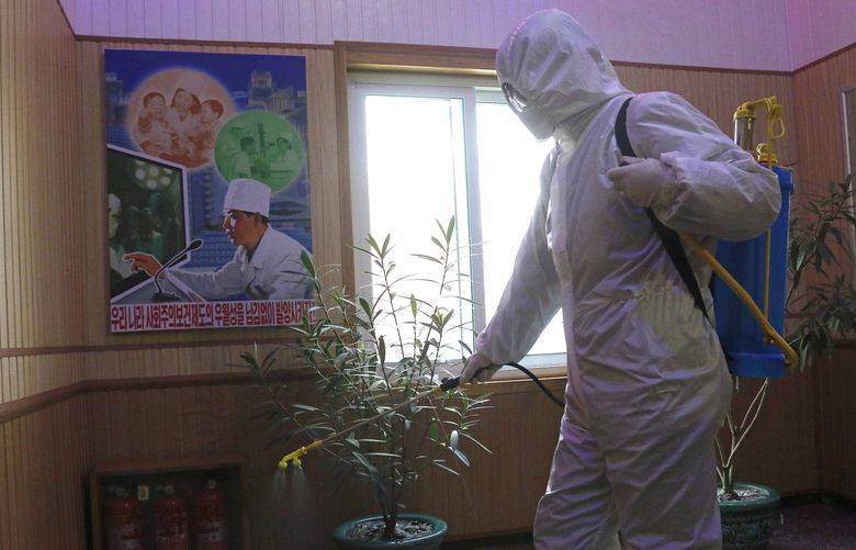 FILE- An official of the Hygienic and Anti-epidemic Center in Phyongchon District disinfect the corridor of a building in Pyongyang, North Korea, on Feb. 5, 2021. The Korean Central News Agency said Thursday, May 12, 2022, tests from an unspecified number of people in the capital Pyongyang confirmed that they were infected with the omicron variant. (AP Photo/Jon Chol Jin, File) TKMY101 TKMY101