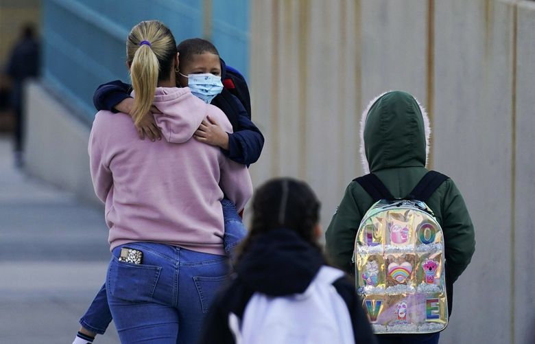 FILE – Children and their caregivers arrive for school in New York, March 7, 2022. U.S. COVID-19 cases are up, leading a smattering of school districts, particularly in the Northeast, to bring back mask mandates and recommendations for the first time since the omicron winter surge ended and as the country approaches 1 million deaths in the pandemic. (AP Photo/Seth Wenig, File) NYAG903 NYAG903