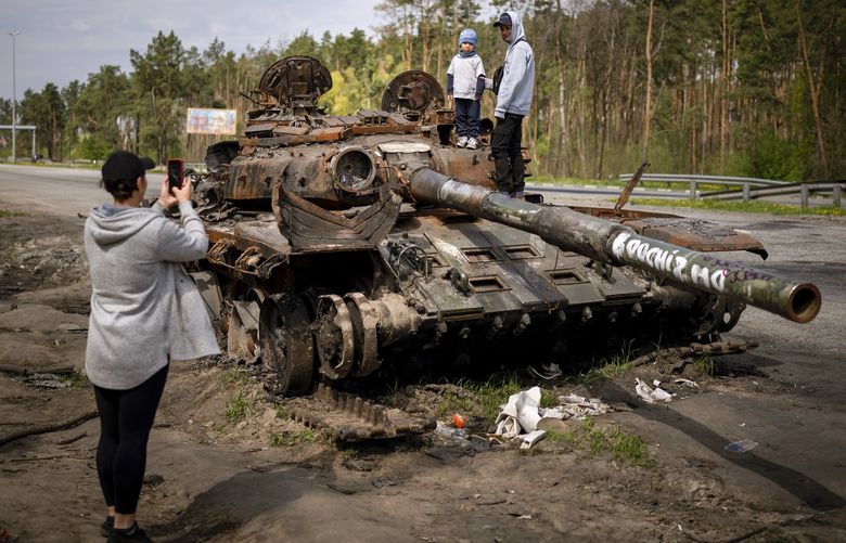 Maksym, 3, is photographed with his brother, Dmytro, 16, on top of a destroyed Russian tank, on the outskirts of Kyiv, Ukraine, May 8, 2022. An interminable and unwinnable war in Europe? That’s what NATO leaders fear and are bracing for as Russia’s war in Ukraine grinds into its third month with little sign of a decisive military victory for either side, and no resolution in sight. (AP Photo/Emilio Morenatti, File) WX206 WX206