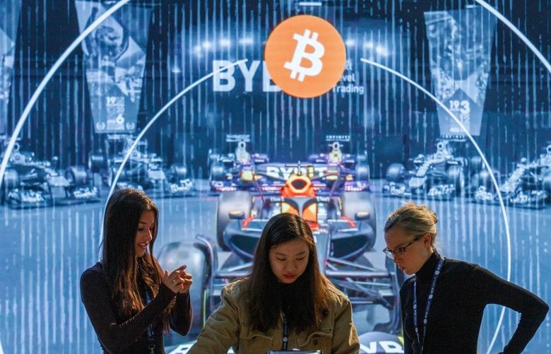 Exhibitors work near a bitcoin logo at the CryptoCompare Digital Asset Summit at Old Billingsgate in London, U.K., on Wednesday, March 30, 2022. Bitcoin and other cryptocurrencies had been, up until the last few weeks, mired in a similar downtrend as other riskier assets, like U.S. stocks. (Bloomberg)