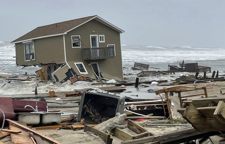 In this image provided by National Park Service, a beach house that collapsed along North Carolina’s Outer Banks rest in the water on Tuesday, May 10, 2022, in Rodanthe, N.C. The home was located along Ocean Drive in the Outer Banks community of Rodanthe. The park service has closed off the area and warned that additional homes in the area may fall too.   (National Park Service via AP) NCHO202 NCHO202