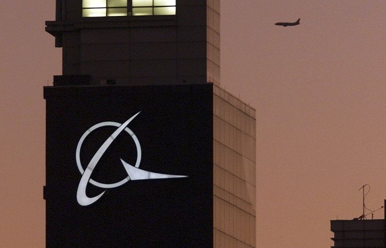 FILE – An airplane flies past the Boeing logo on the company’s headquarters in Chicago, on Thursday, Dec. 20, 2001. Boeing Co., a leading defense contractor and one of the world’s two dominant manufacturers of airline planes, is expected to move its headquarters from Chicago to the Washington, D.C., area, according to two people familiar with the matter. The decision could be announced as soon as later Thursday, May 5, 2022, according to one of the people. (AP Photo/Ted S. Warren, File) NYPH500 NYPH500