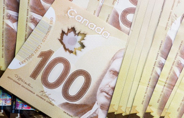Canadian one hundred dollar banknotes are arranged for a photograph in Toronto, Ontario, Canada. Photographer: Brent Lewin/Bloomberg