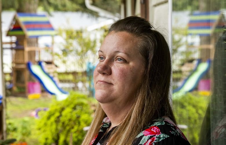 Jessica Heavner on her porch at her Federal Way home on Thursday, May 12, 2022. Heavner, who works for the school district, believes that a raise from the district would push her over the income threshold for state-subsidized childcare.