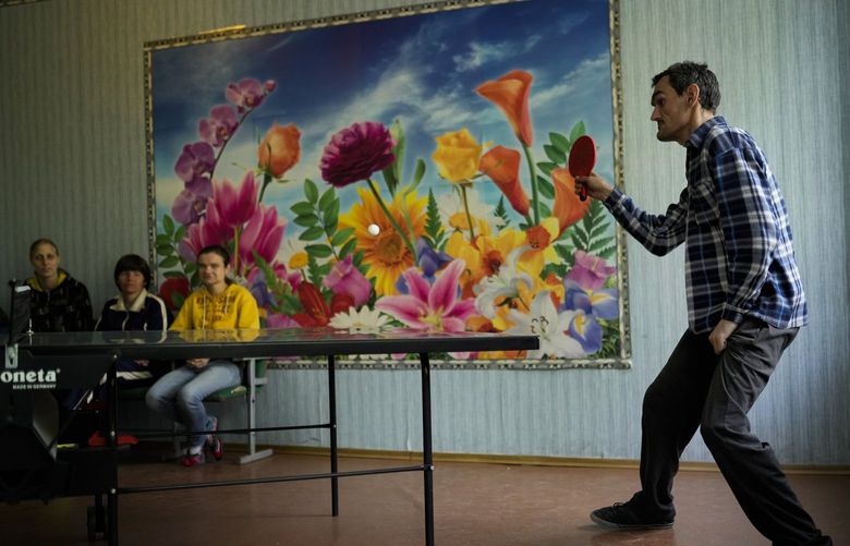 Residents play table tennis in a facility for people with mental and physical disabilities in the village of Tavriiske, Ukraine, Wednesday, May 11, 2022. The staff is faced with the dilemma of evacuating the facility, and how to do it with minimum disruption to the residents, some of whom have very severe disabilities and others for whom changes in environment can be disorientating and highly stressful. (AP Photo/Francisco Seco) FS104 FS104