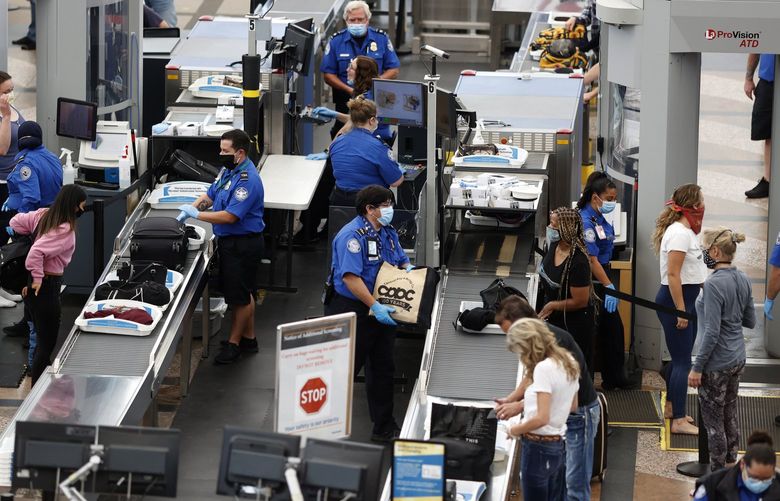 FILE – Transportation Security Administration agents process passengers at the south security checkpoint at Denver International Airport in Denver on June 10, 2020. The chief of the TSA said Tuesday, May 10, 2022, that his agency has quadrupled the number of employees who could bolster screening operations at airports that become too crowded this summer. (AP Photo/David Zalubowski, File) NYBZ950 NYBZ950
