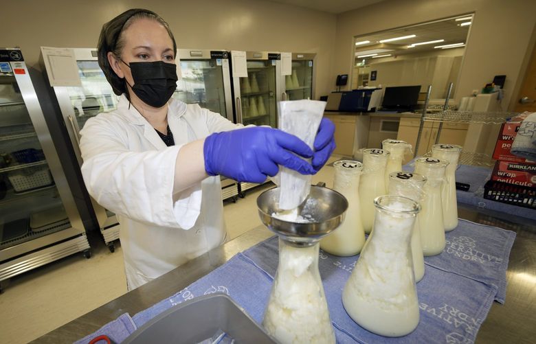 Rebecca Heinrich, director of the Mothers’ Milk Bank, loads frozen milk donated by lactating mothers from plastic bags into bottles for distribution to babies Friday, May 13, 2022, at the foundation’s headquarters in Arvada, Colo. (AP Photo/David Zalubowski) CODZ124 CODZ124