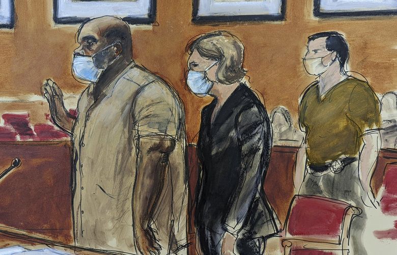 In this courtroom sketch, Frank James, left, the man accused in a mass shooting on a subway train in the Brooklyn borough of New York, is sworn-in during his arraignment in federal court, Friday, May 13, 2022, in New York. His defense attorney Mia Eisner-Grynberg is at center. James, 62, is facing charges of committing a terrorist attack or other violence against a mass transportation system and discharging a firearm during a violent crime. Both counts carry a maximum sentence of life in prison.  (AP Photo/Elizabeth Williams) NYRD502 NYRD502