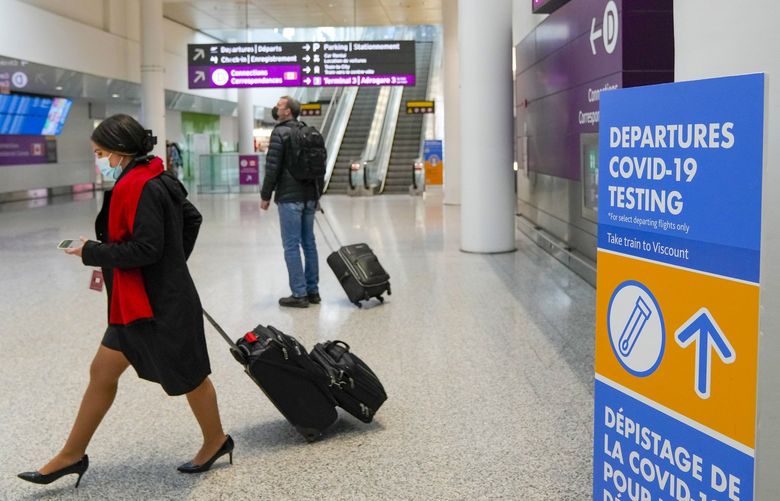 People travel at Pearson International Airport during the COVID-19 pandemic in Toronto, Friday, Dec. 3, 2021. New travel testing and restrictions have been put in place due to the omicron variant. (Nathan Denette / The Canadian Press via AP) NSD108