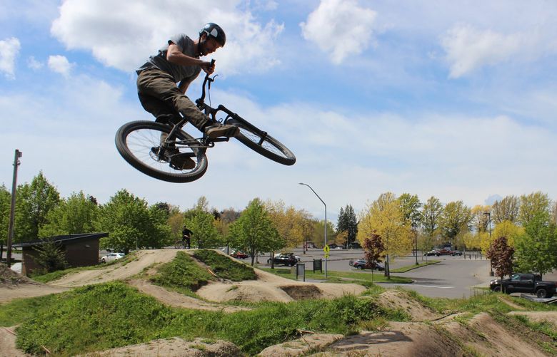 Evil Bikes employee Cole Cook spends his lunch break catching air at the Civic Dirt Jump Park in Bellingham.