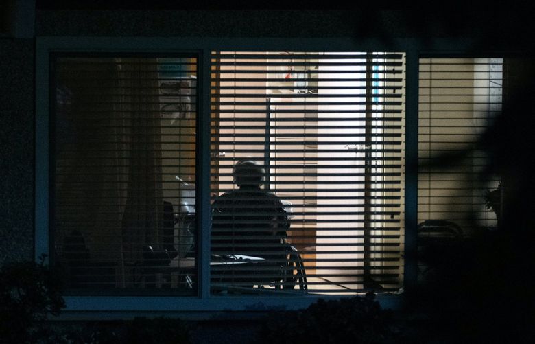 FILE — A resident is seen through a window at the Life Care Center of Kirkland, Wash., on March 16, 2020. Even before the coronavirus swept through care facilities, many were struggling with thin profit margins.  (Grant Hindsley/The New York Times) XNYT94