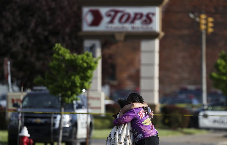 People hug outside the scene after a shooting at a supermarket on Saturday, May 14, 2022, in Buffalo, N.Y. (AP Photo/Joshua Bessex) NYJB120 NYJB120