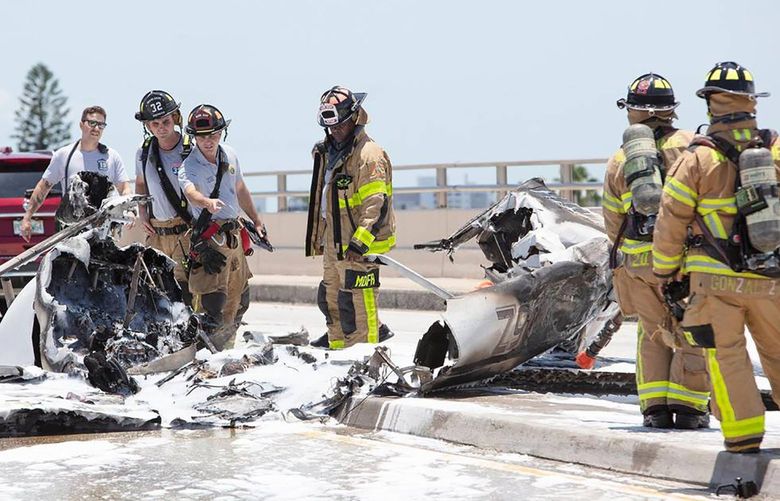 Firefighters work at the scene of a plane crash at the Haulover Inlet Bridge on Saturday, May 14, 2022, in Miami. (Andrew Uloza/Miami Herald/TNS) 47882962W 47882962W