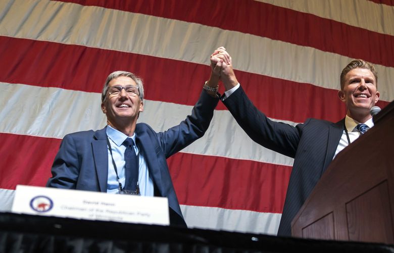 GOP gubernatorial candidate Dr. Scott Jensen, left, takes the stage with running mate Matt Birk, Saturday, May 14, 2022, in Rochester, Minn., at the second day of the Minnesota Republicans state convention. (Glen Stubbe/Star Tribune via AP) MNMIT821 MNMIT821