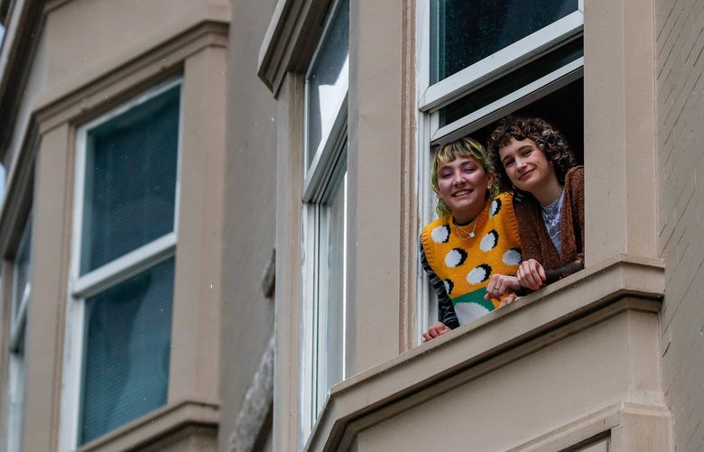 Downtown Seattle – sign language fire rescue – 051522
Kendal Sprague, left, and Gracie Reynolds lean out of the window of their downtown Seattle apartment building Sunday, May 15, 2022, in Seattle, Wash. Sprague and Reynolds saw a fire across I-5 from their building, called 9-1-1 and then went over to the fire where they saw two people who were stranded on a balcony. They realized they were deaf and Reynolds communicated with them in sign language she had learned in high school that help was on the way. 220404