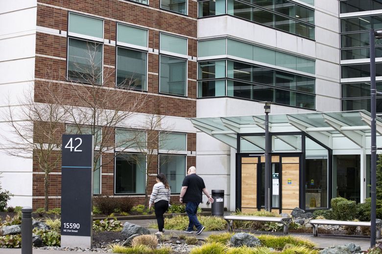 Employees walk into Microsoft Building 42 on the east campus in Redmond on Monday, Feb. 14, 2022. Microsoft announced Monday that it will reopen its Washington offices later this month. (Amanda Snyder / The Seattle Times)