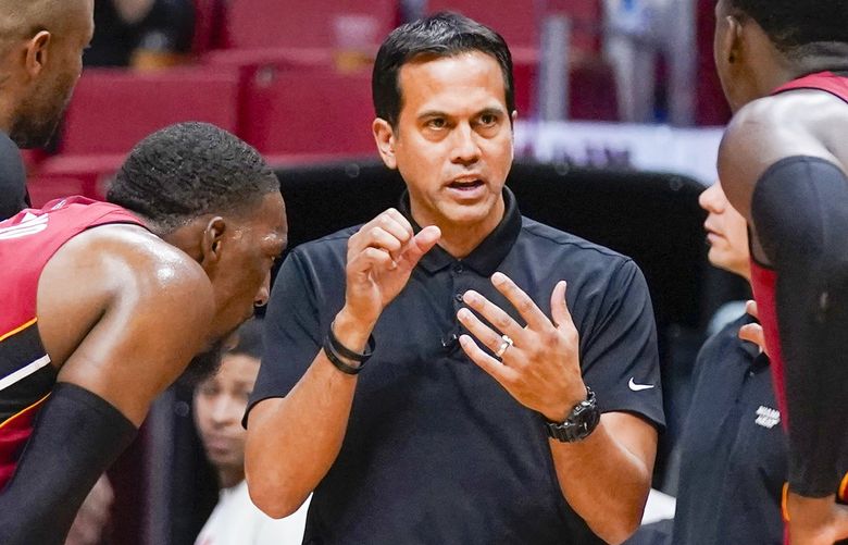 Miami Heat head coach Erik Spoelstra, center, talks with players as officials review a play during the second half of Game 5 of an NBA basketball first-round playoff series against the Atlanta Hawks, Tuesday, April 26, 2022, in Miami. (AP Photo/Wilfredo Lee) AAA121
