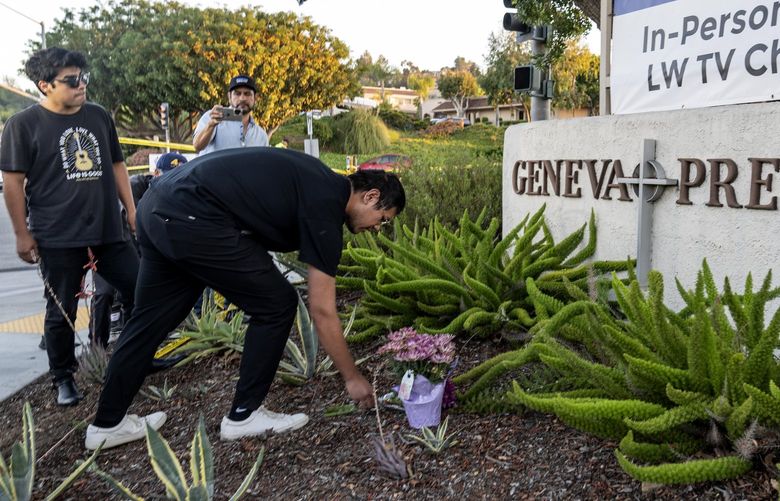 Hector Gomez, left, and Jordi Poblete, worship leaders at the Mariners Church Irvine, leave flowers outside the Geneva Presbyterian Church in Laguna Woods, Calif., Sunday, May 15, 2022, after a fatal shooting. (AP Photo/Damian Dovarganes) CADD721 CADD721